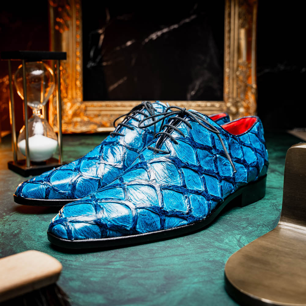 A pair of Marco Di Milano Olivieri Caribbean Blue crocodile leather oxfords with red interior lining; one shoe stands upright, the other shows its sole with "Marco Di Milano" branding.