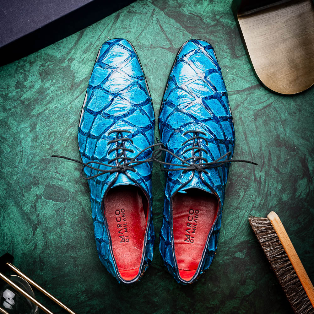 A pair of Marco Di Milano Olivieri Caribbean Blue crocodile leather oxfords with red interior lining; one shoe stands upright, the other shows its sole with "Marco Di Milano" branding.