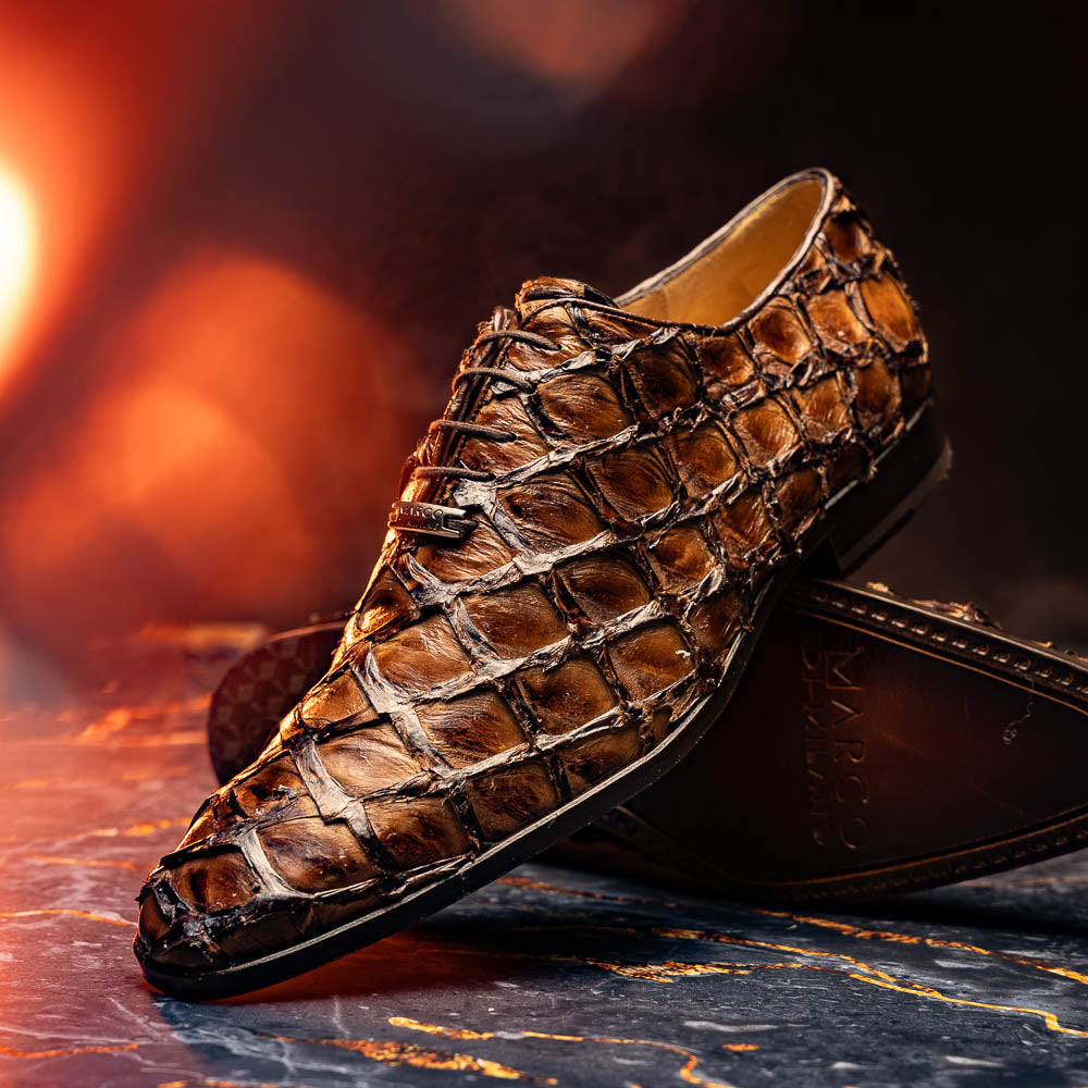 The Olivieri Clear Brown oxford shoes by Marco Di Milano showcase a textured crocodile leather design; one shoe stands upright as the other lies on its side, displaying the sole.