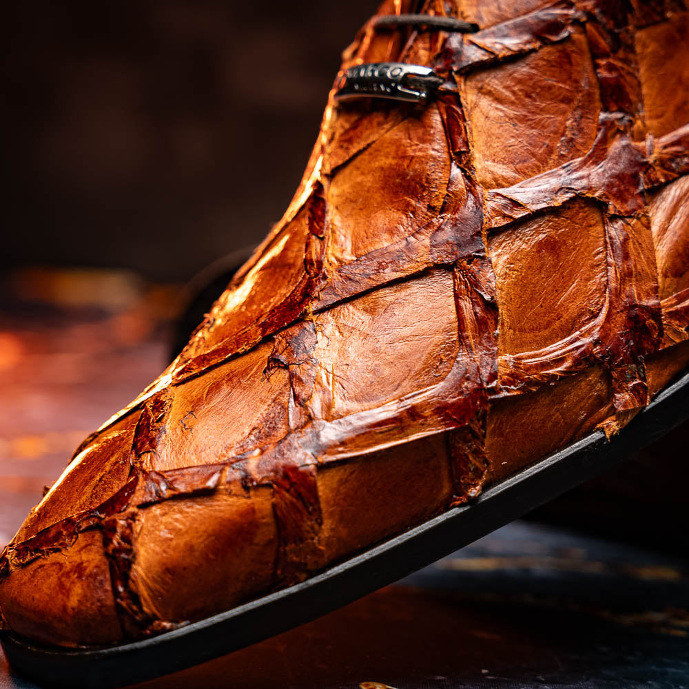 A pair of Olivieri Cognac dress shoes by Marco Di Milano, crafted from brown crocodile leather with black laces—one shoe stands upright, the other shows its sole—ideal for lovers of luxury footwear.
