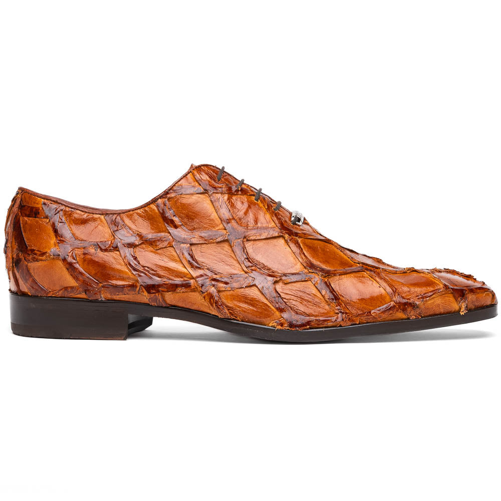 A pair of Olivieri Cognac dress shoes by Marco Di Milano, crafted from brown crocodile leather with black laces—one shoe stands upright, the other shows its sole—ideal for lovers of luxury footwear.