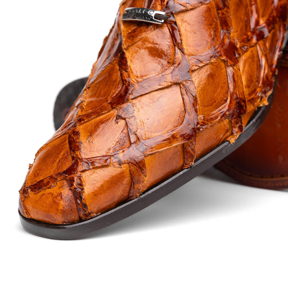 A pair of Olivieri Cognac dress shoes by Marco Di Milano, crafted from brown crocodile leather with black laces—one shoe stands upright, the other shows its sole—ideal for lovers of luxury footwear.