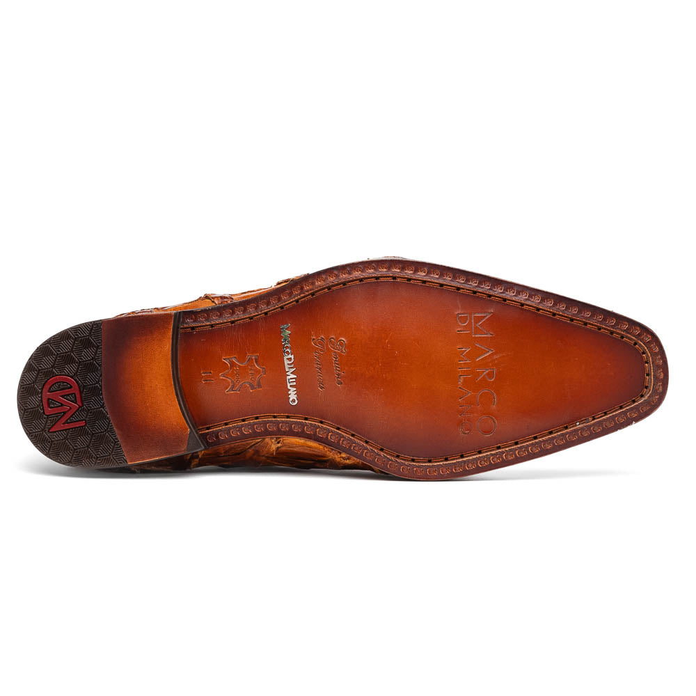 A pair of Olivieri Cognac dress shoes by Marco Di Milano, crafted from brown crocodile leather with black laces—one shoe stands upright, the other shows its sole—ideal for lovers of luxury footwear.