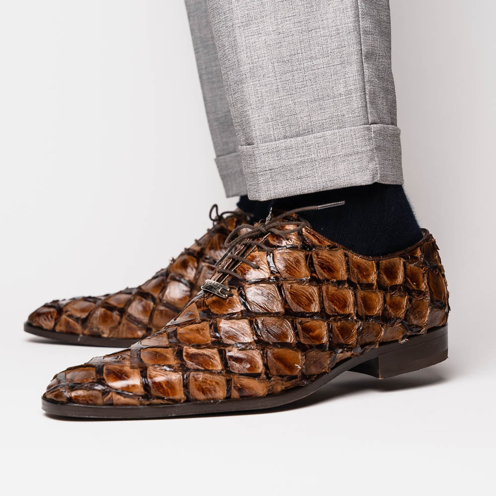 The Olivieri Clear Brown oxford shoes by Marco Di Milano showcase a textured crocodile leather design; one shoe stands upright as the other lies on its side, displaying the sole.