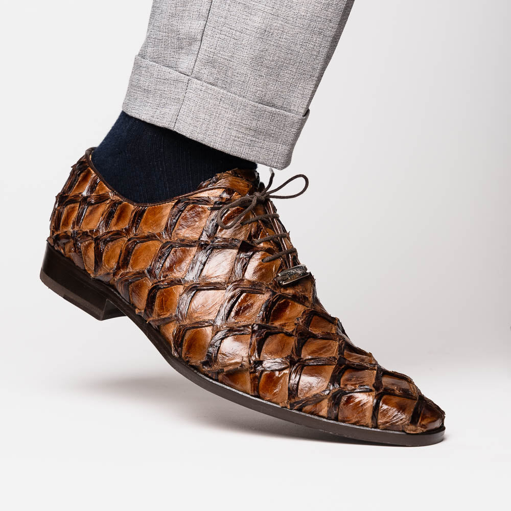 The Olivieri Clear Brown oxford shoes by Marco Di Milano showcase a textured crocodile leather design; one shoe stands upright as the other lies on its side, displaying the sole.