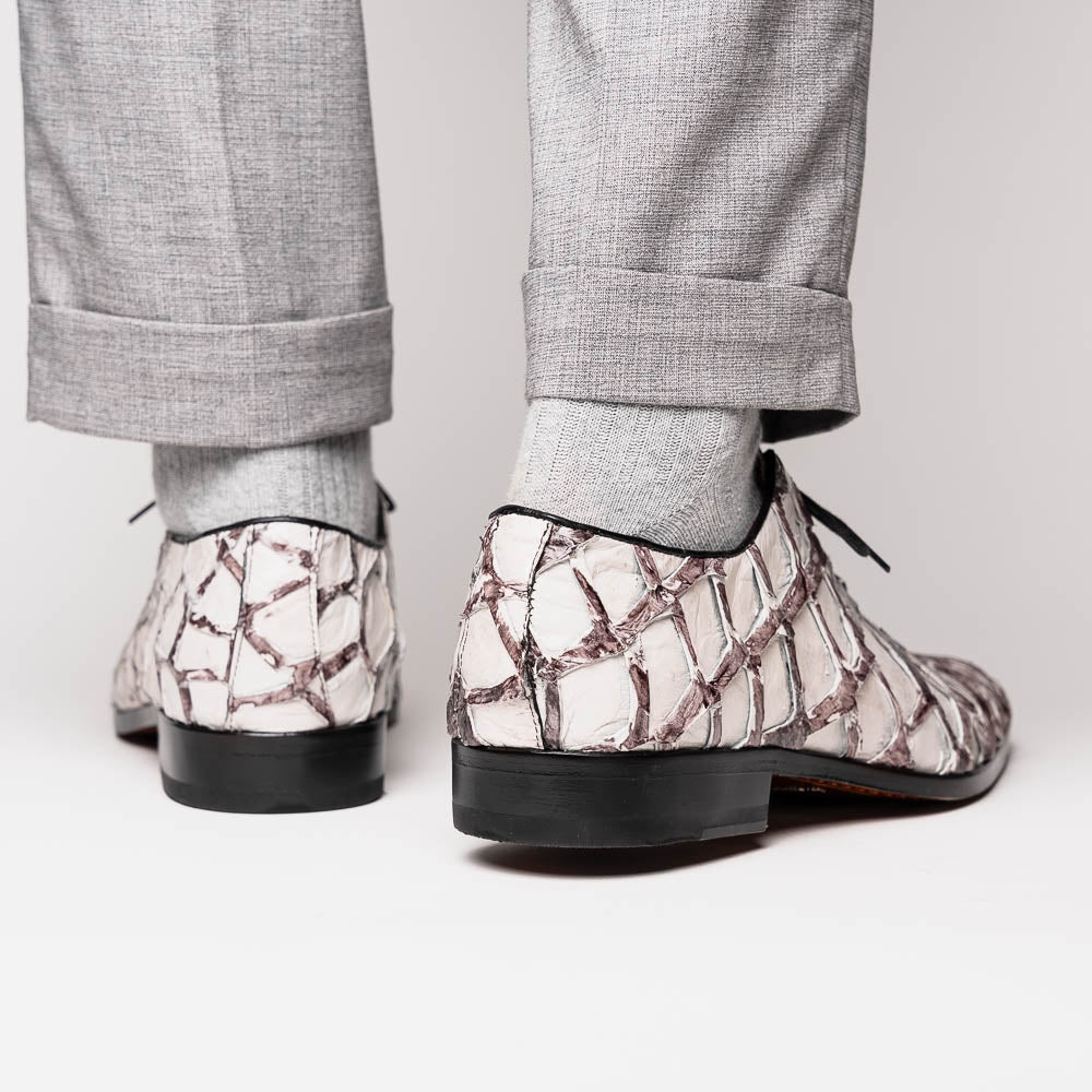 The Marco Di Milano Olivieri Newspaper is a luxury dress oxford featuring a white and gray pattern, black laces, red lining, and brown leather soles—crafted from genuine pirarucu for an elegant statement.