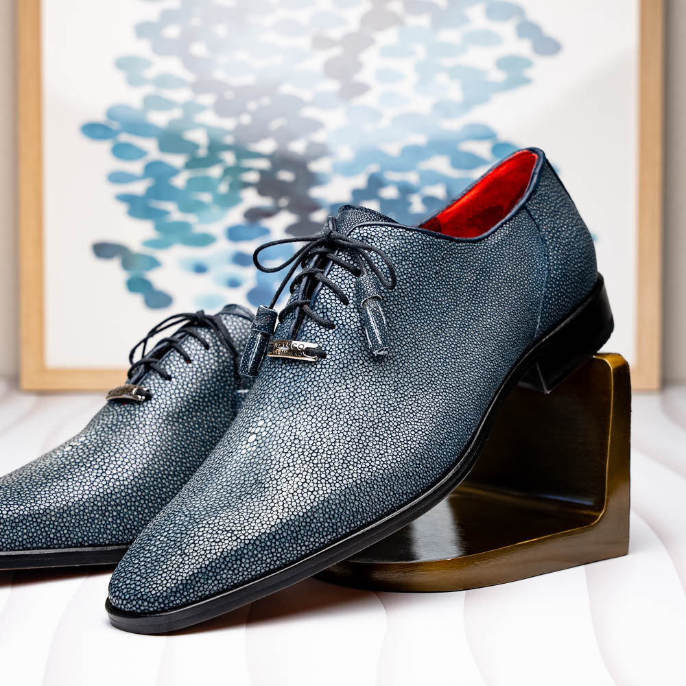 A pair of Marco Di Milano Pannuci Navy dress oxford shoes in textured dark blue leather with black laces, red inner lining, and tan soles—one displayed on its side to showcase the branded sole.