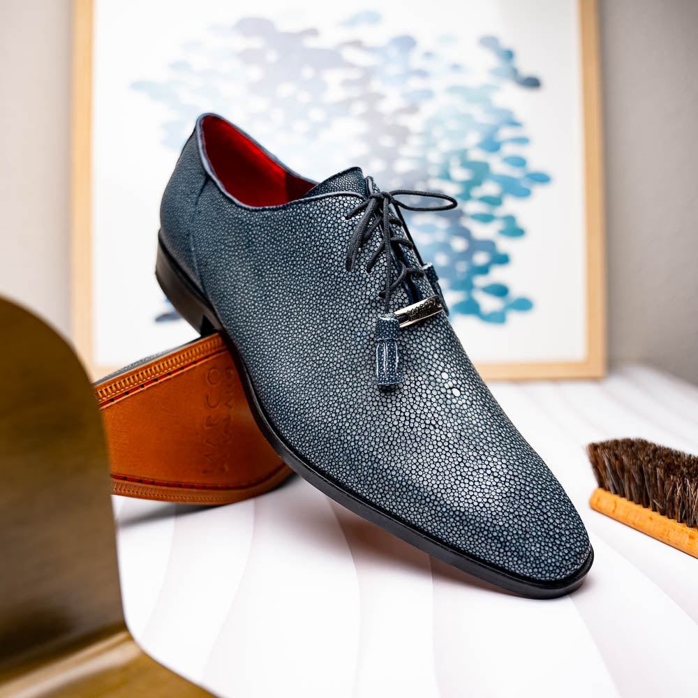 A pair of Marco Di Milano Pannuci Navy dress oxford shoes in textured dark blue leather with black laces, red inner lining, and tan soles—one displayed on its side to showcase the branded sole.