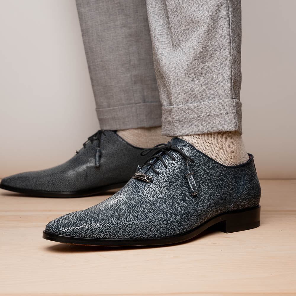 A pair of Marco Di Milano Pannuci Navy dress oxford shoes in textured dark blue leather with black laces, red inner lining, and tan soles—one displayed on its side to showcase the branded sole.