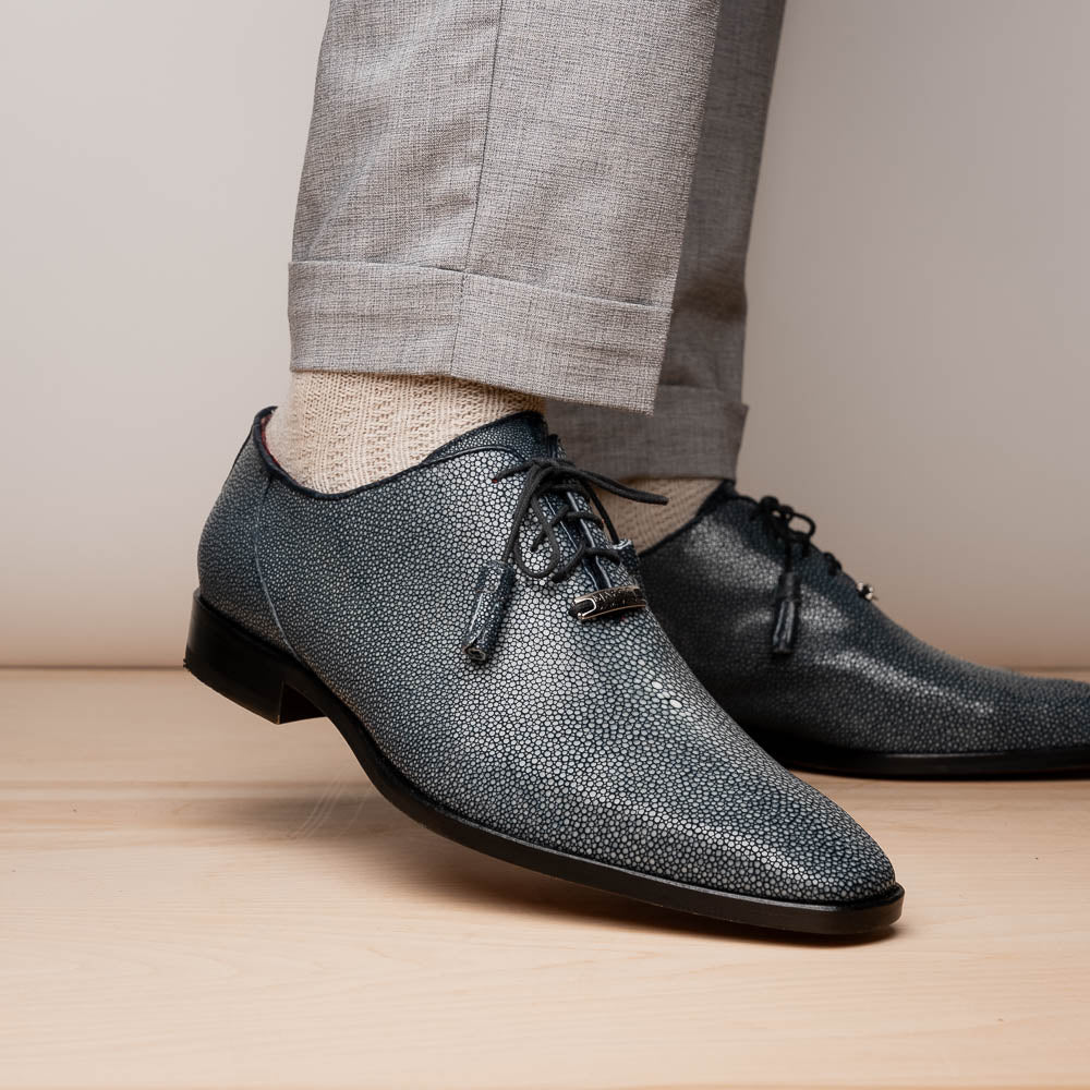 A pair of Marco Di Milano Pannuci Navy dress oxford shoes in textured dark blue leather with black laces, red inner lining, and tan soles—one displayed on its side to showcase the branded sole.