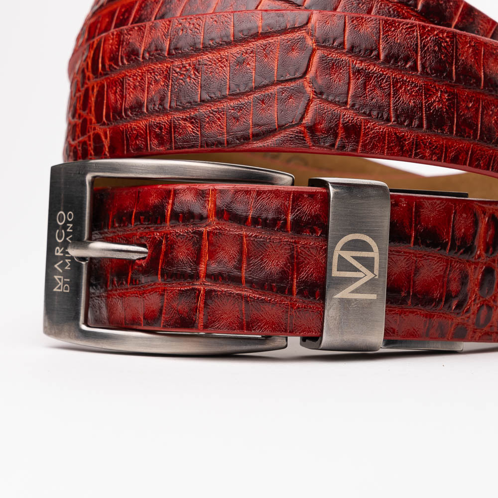 The Riccardo Belt Antique Red by Marco Di Milano is a rolled, red caiman belly belt with a crocodile pattern and a silver buckle engraved with the brand logo—an exceptional choice in luxury exotic belts.