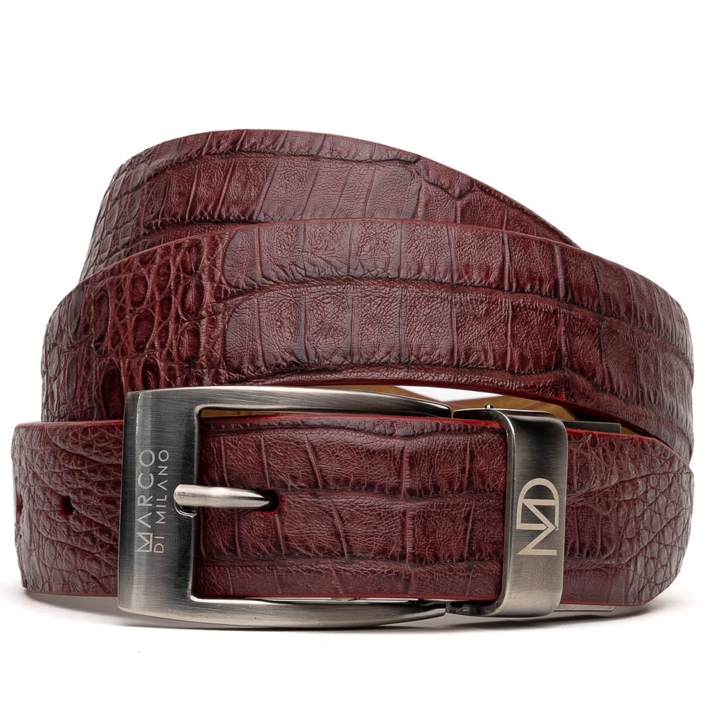 The Riccardo Belt Wine by Marco Di Milano is a maroon caiman belly leather belt with a crocodile pattern and a silver buckle engraved with the brand name and logo—an elegant choice for refined style.