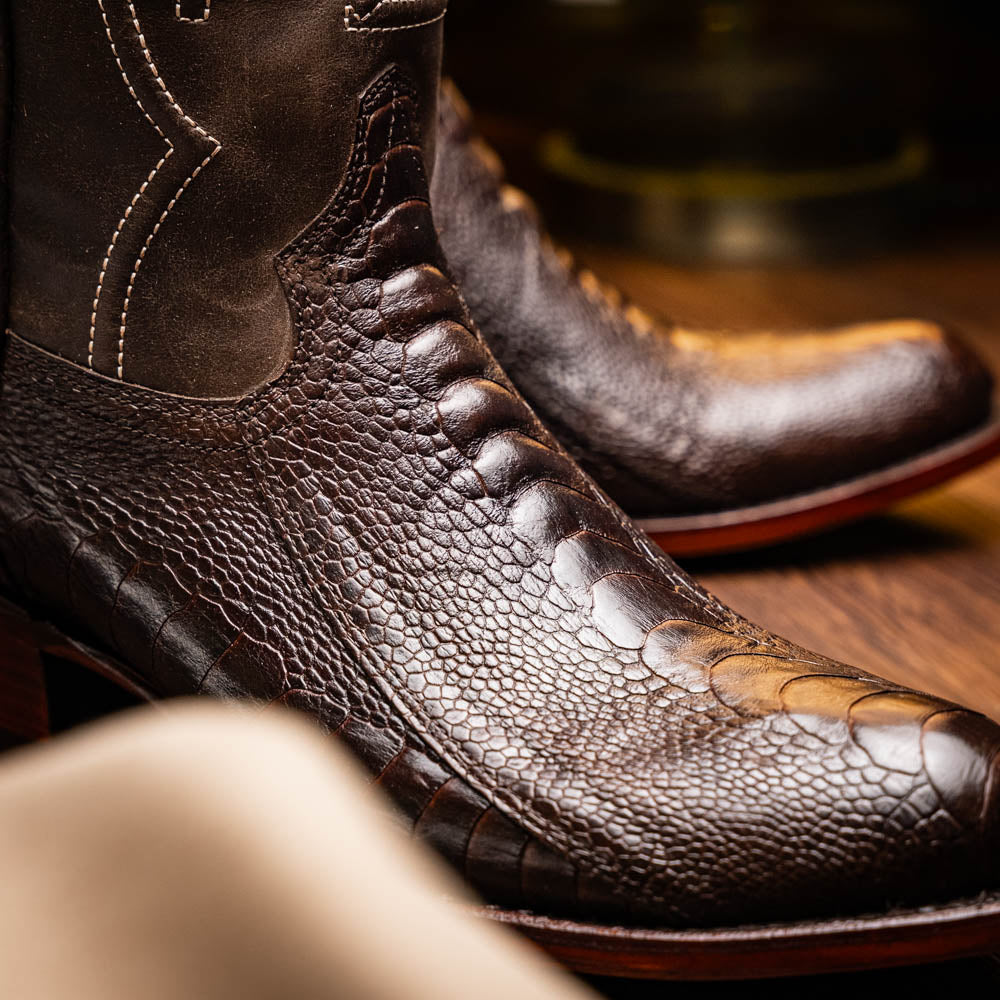 A pair of Denver Brown Western boots by Marco Di Milano in dark brown textured leather, featuring contrast stitching and genuine ostrich style; one boot shows the branded sole.