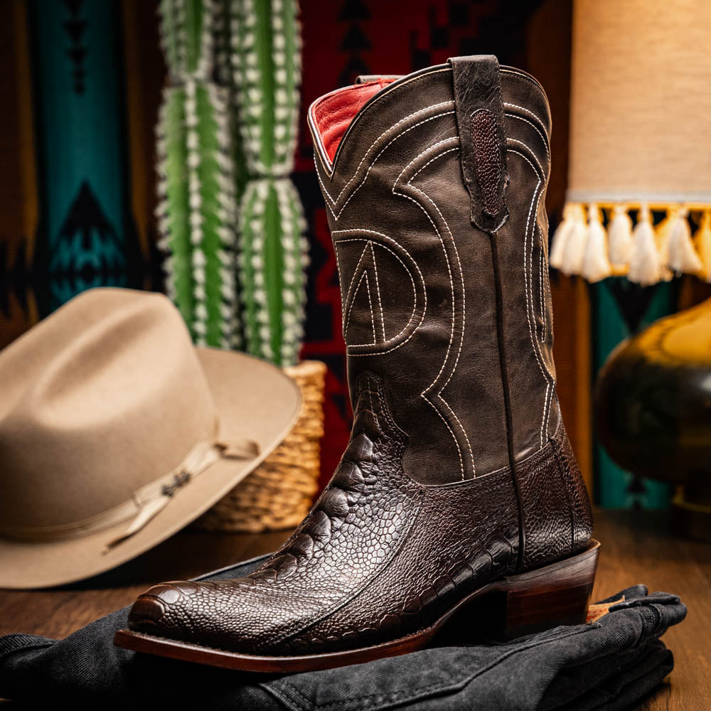A pair of Denver Brown Western boots by Marco Di Milano in dark brown textured leather, featuring contrast stitching and genuine ostrich style; one boot shows the branded sole.