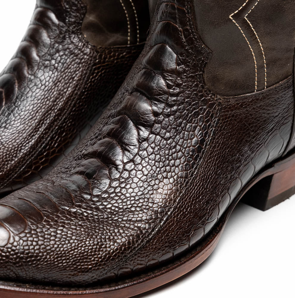 A pair of Denver Brown Western boots by Marco Di Milano in dark brown textured leather, featuring contrast stitching and genuine ostrich style; one boot shows the branded sole.