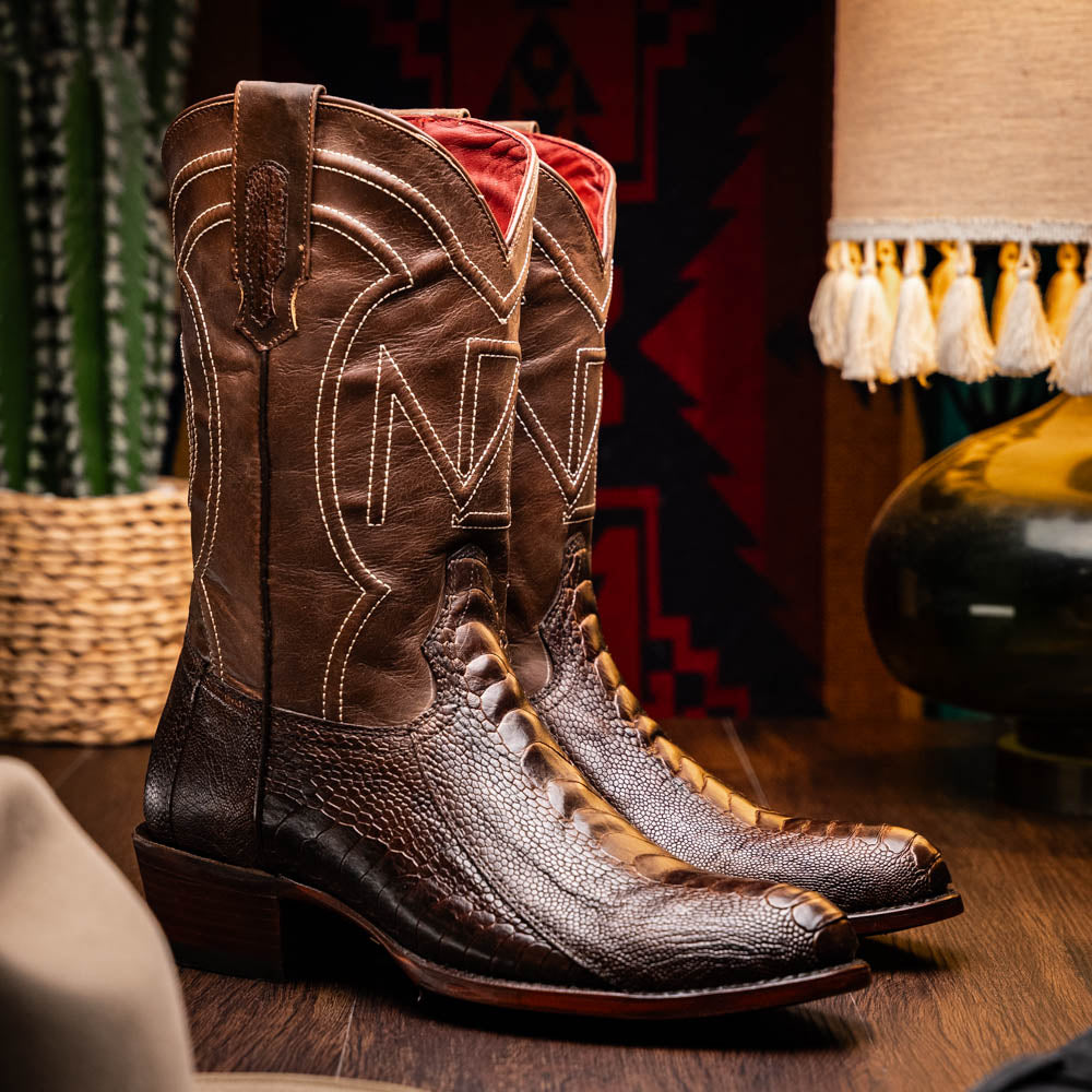 The Denver Clear Brown by Marco Di Milano are textured leather Western cowboy boots in brown, featuring white stitching and branded soles.