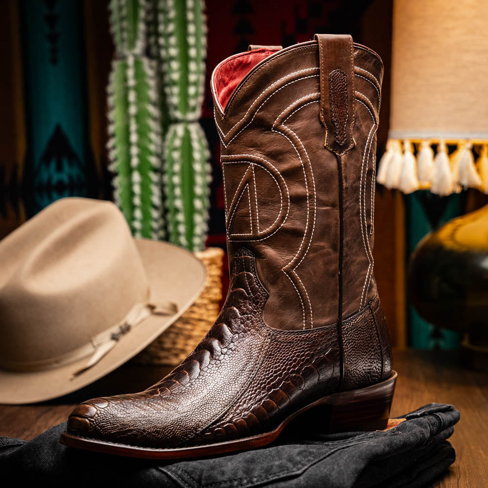 The Denver Clear Brown by Marco Di Milano are textured leather Western cowboy boots in brown, featuring white stitching and branded soles.