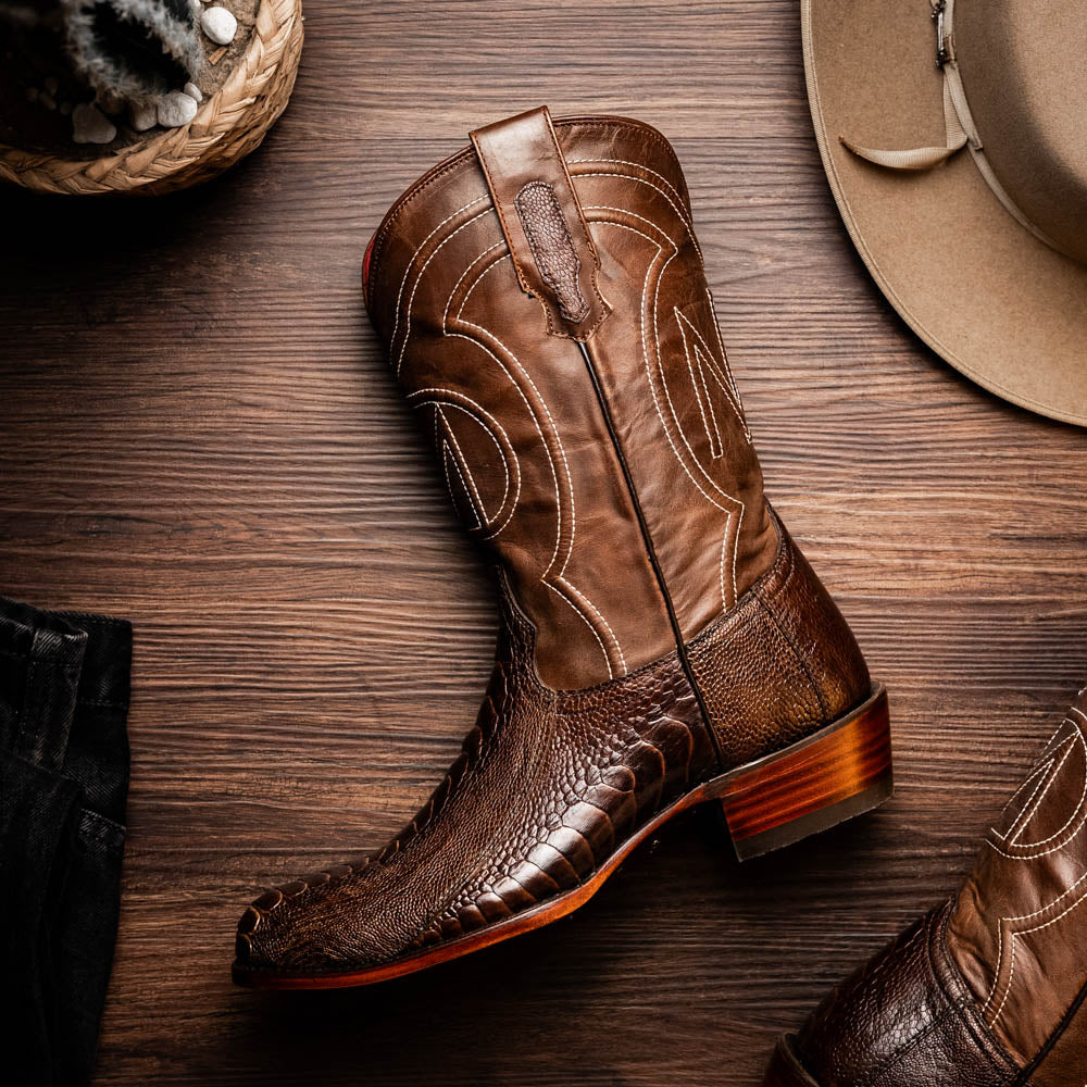 The Denver Clear Brown by Marco Di Milano are textured leather Western cowboy boots in brown, featuring white stitching and branded soles.
