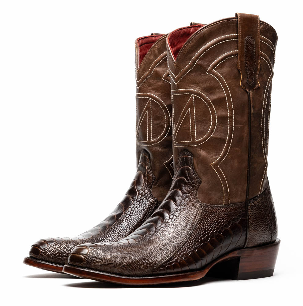 The Denver Clear Brown by Marco Di Milano are textured leather Western cowboy boots in brown, featuring white stitching and branded soles.