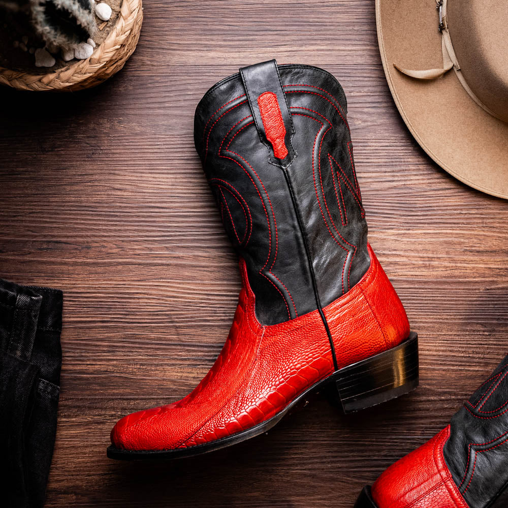 The Denver Red boots by Marco Di Milano feature bold red and black genuine ostrich skin—one boot upright, one showing the sole with the signature logo—for a striking, luxurious Western style.