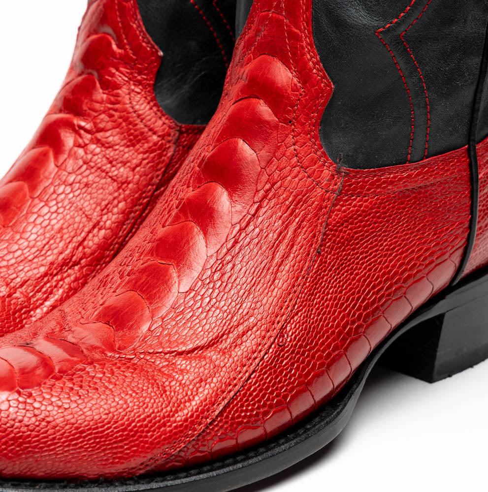 The Denver Red boots by Marco Di Milano feature bold red and black genuine ostrich skin—one boot upright, one showing the sole with the signature logo—for a striking, luxurious Western style.