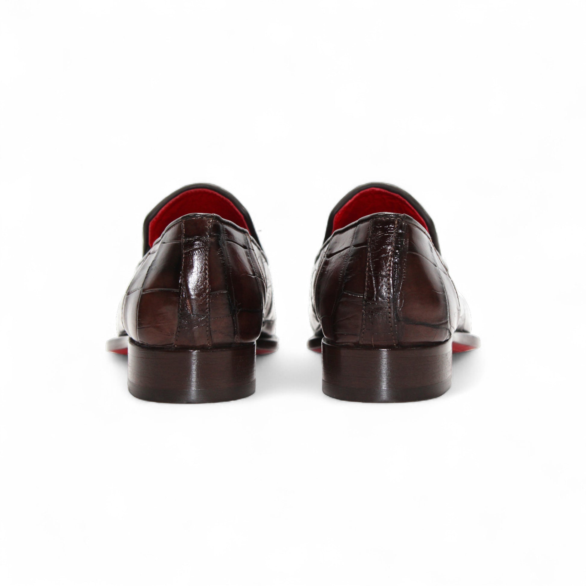 The Fennix Dustin Brown loafer by Fennix of Italy features premium brown leather, Italian craftsmanship, a textured pattern, low heel, and red interior lining, showcased in a side profile against a white background.