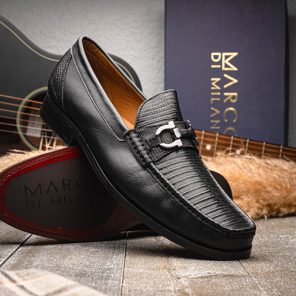 The Enzo Black by Marco Di Milano: black textured genuine lizard loafers with metal bit detail—one upright, one showing a brown sole stamped with "MARCO DI MILANO"—perfect for fans of luxury men's footwear.