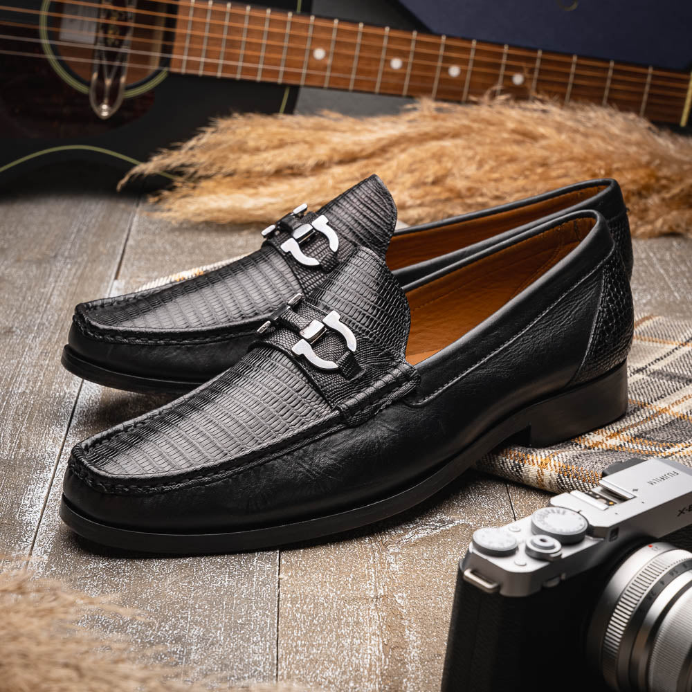 The Enzo Black by Marco Di Milano: black textured genuine lizard loafers with metal bit detail—one upright, one showing a brown sole stamped with "MARCO DI MILANO"—perfect for fans of luxury men's footwear.