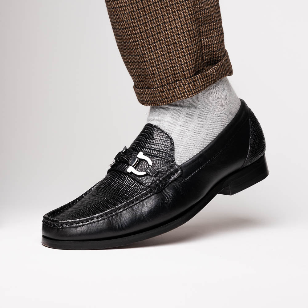 The Enzo Black by Marco Di Milano: black textured genuine lizard loafers with metal bit detail—one upright, one showing a brown sole stamped with "MARCO DI MILANO"—perfect for fans of luxury men's footwear.