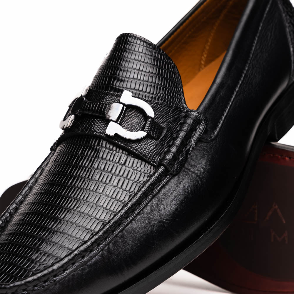 The Enzo Black by Marco Di Milano: black textured genuine lizard loafers with metal bit detail—one upright, one showing a brown sole stamped with "MARCO DI MILANO"—perfect for fans of luxury men's footwear.