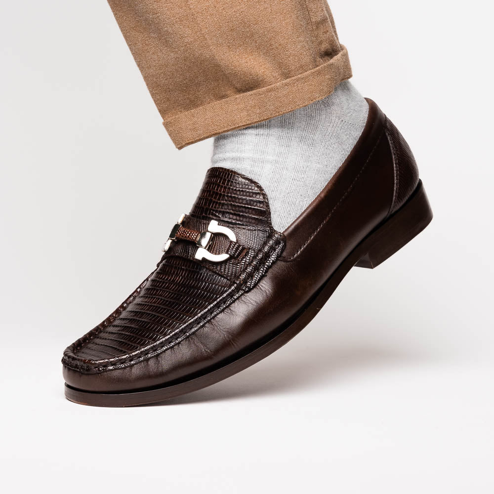 The Enzo Brown by Marco Di Milano features dark brown genuine lizard loafers with textured uppers, a metal buckle, and branded soles—luxurious men's footwear displayed against a white background.