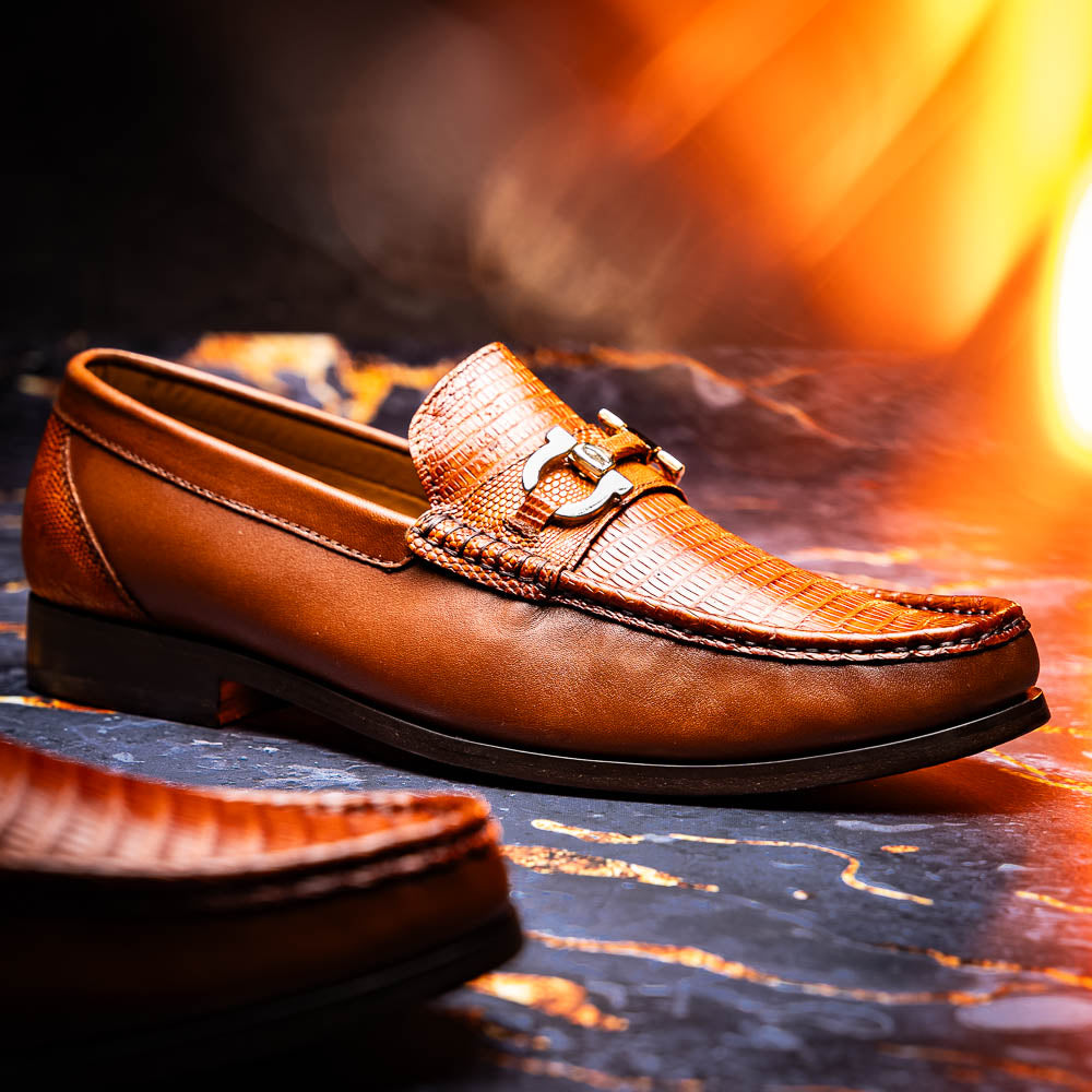The Enzo Cognac by Marco Di Milano: men's brown leather loafers with a textured pattern, hand-painted finish, gold buckle, and black soles, shown on a white background.
