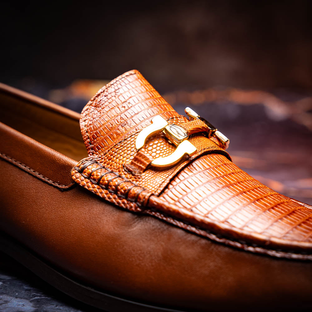 The Enzo Cognac by Marco Di Milano: men's brown leather loafers with a textured pattern, hand-painted finish, gold buckle, and black soles, shown on a white background.