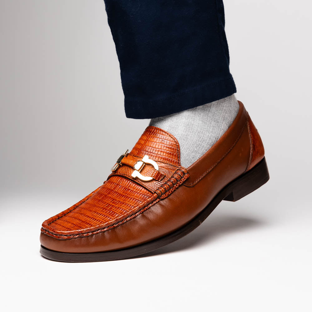 The Enzo Cognac by Marco Di Milano: men's brown leather loafers with a textured pattern, hand-painted finish, gold buckle, and black soles, shown on a white background.