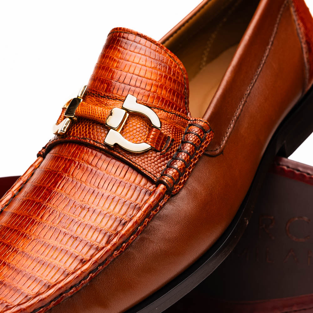 The Enzo Cognac by Marco Di Milano: men's brown leather loafers with a textured pattern, hand-painted finish, gold buckle, and black soles, shown on a white background.