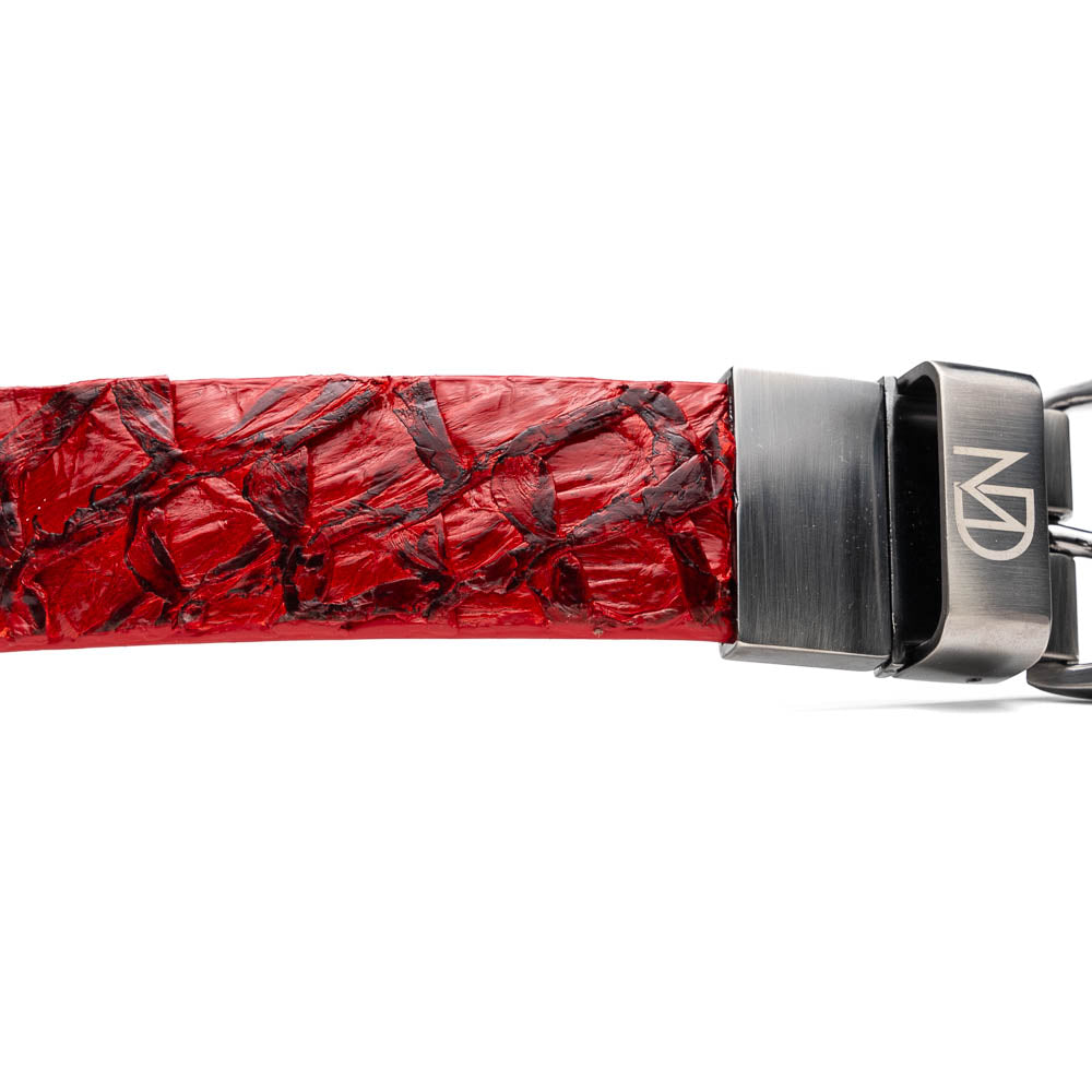 The Olivieri Belt Red by Marco Di Milano features textured genuine pirarucu leather and a metallic buckle with engraved branding, coiled on a white background—a signature accessory from this renowned luxury brand.