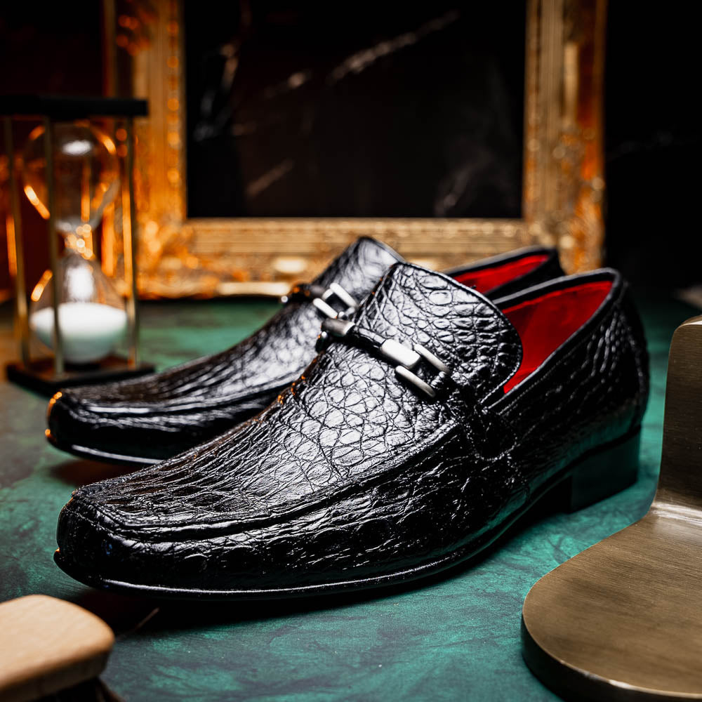 A pair of Fabro-Tin Black textured men's shoes by Marco Di Milano, featuring metal accents—one upright and one on its side showing the branded tan sole.