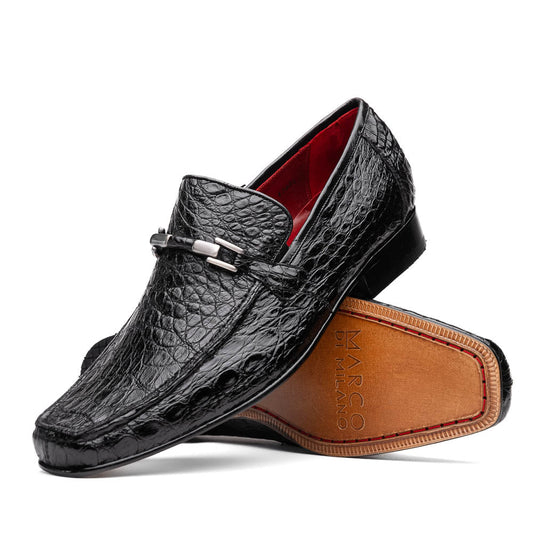 A pair of Fabro-Tin Black textured men's shoes by Marco Di Milano, featuring metal accents—one upright and one on its side showing the branded tan sole.