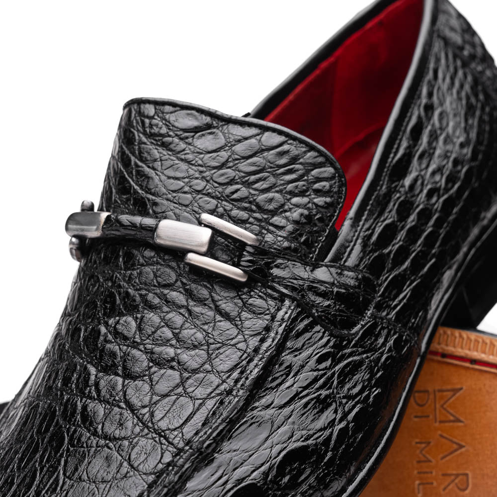 A pair of Fabro-Tin Black textured men's shoes by Marco Di Milano, featuring metal accents—one upright and one on its side showing the branded tan sole.