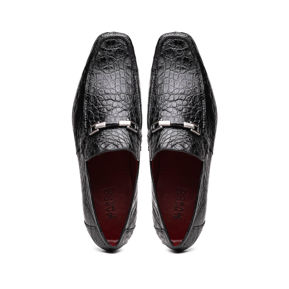 A pair of Fabro-Tin Black textured men's shoes by Marco Di Milano, featuring metal accents—one upright and one on its side showing the branded tan sole.