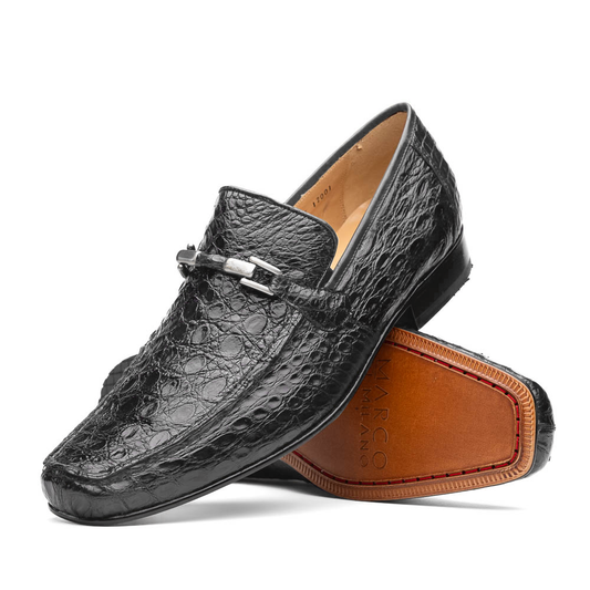 A pair of Marco Di Milano Fabro-Tin Gray loafers—one upright, one on its side revealing the brown sole—exemplify luxury men's footwear.