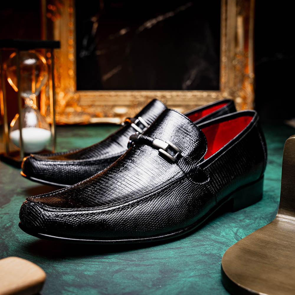 A pair of Marco Di Milano Fabro-Liz Black genuine lizard loafers, featuring textured leather, metal accents, and brown soles—one upright, the other on its side showing the luxury men's shoes branding on the sole.