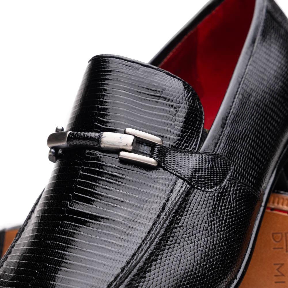 A pair of Marco Di Milano Fabro-Liz Black genuine lizard loafers, featuring textured leather, metal accents, and brown soles—one upright, the other on its side showing the luxury men's shoes branding on the sole.