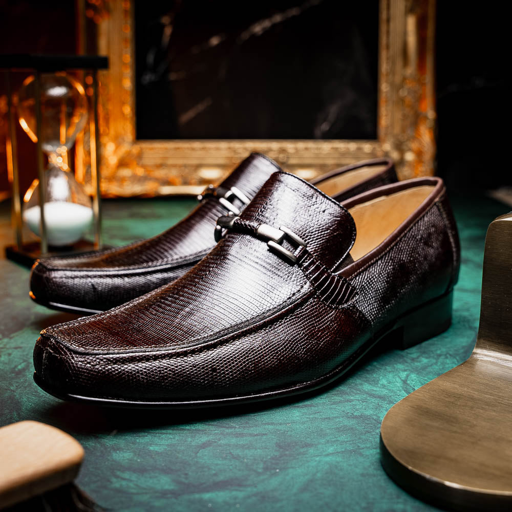 The Marco Di Milano Fabro-Liz Brown loafers feature a textured lizard finish, silver buckle detail, and tan leather soles—ideal for luxury footwear enthusiasts.