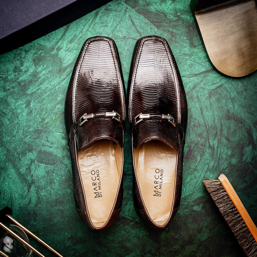 The Marco Di Milano Fabro-Liz Brown loafers feature a textured lizard finish, silver buckle detail, and tan leather soles—ideal for luxury footwear enthusiasts.