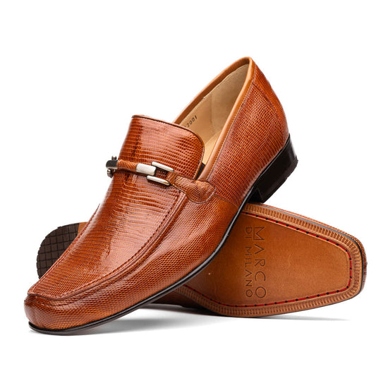 The Marco Di Milano Fabro-Liz Cognac loafers, crafted from brown leather with a textured finish and metal detail, are displayed—one upright and one showing the sole and branding—showcasing refined luxury footwear.
