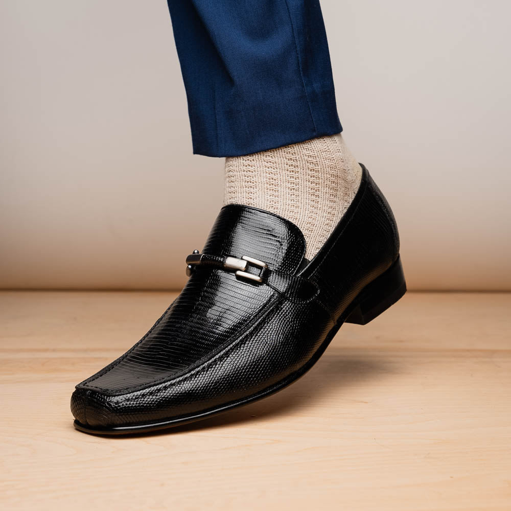 A pair of Marco Di Milano Fabro-Liz Black genuine lizard loafers, featuring textured leather, metal accents, and brown soles—one upright, the other on its side showing the luxury men's shoes branding on the sole.