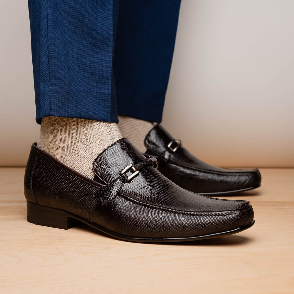 The Marco Di Milano Fabro-Liz Brown loafers feature a textured lizard finish, silver buckle detail, and tan leather soles—ideal for luxury footwear enthusiasts.