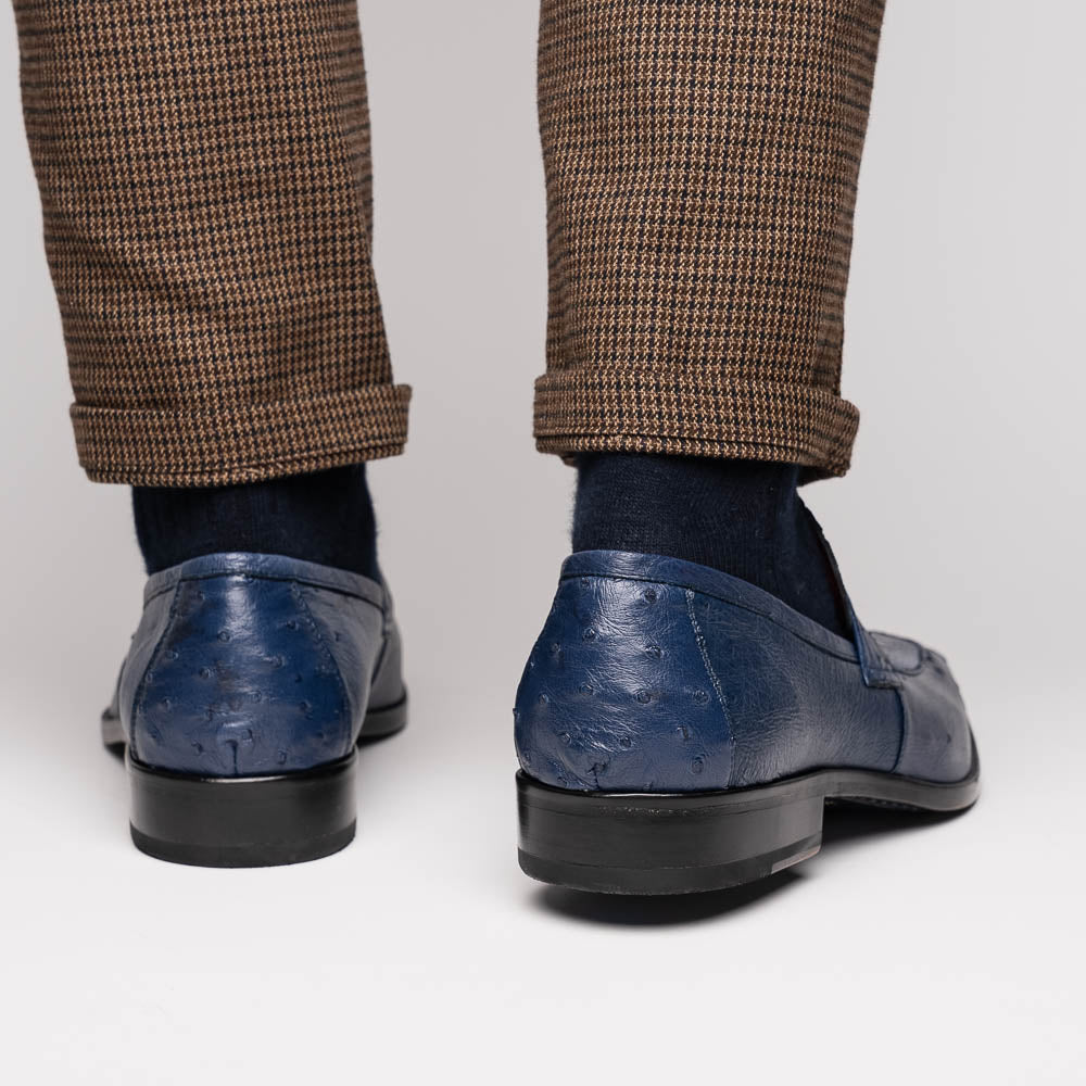 The Marco Di Milano Fangio Denim Blue features genuine ostrich loafers with textured blue uppers and red lining—one upright, one on its side displaying the sole—a standout addition to any luxury men’s footwear collection.
