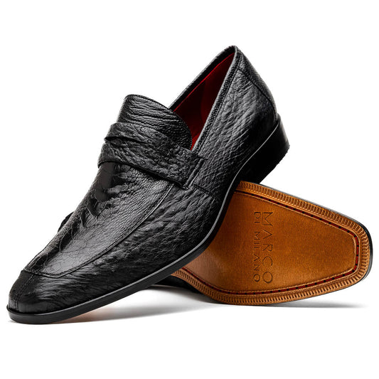 The Fangio Black by Marco Di Milano: a pair of black textured leather loafers, one upright and one sole-up, displaying the brand on the tan sole—luxury men's footwear to elevate any look.